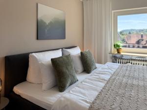a bedroom with a bed with white pillows and a window at Top Penthouse mit großem Balkon und Traumaussicht in Lenzkirch
