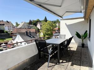a table and chairs on the balcony of a house at Top Penthouse mit großem Balkon und Traumaussicht in Lenzkirch