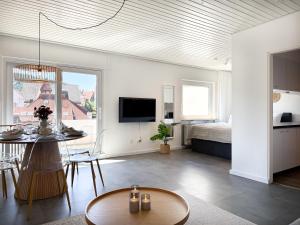 a living room with a table and a bedroom at Top Penthouse mit großem Balkon und Traumaussicht in Lenzkirch