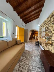 a living room with a couch and a stone wall at Κυθνος Δρυοπίδα, Στούντιο Χατζής in Dhriopís