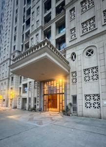 a large building with a glass door in front of it at Cozy studio with Dolby Sounds Hiranandani Estate in Kolshet