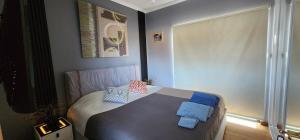 a bedroom with a bed with blue pillows on it at Coorong GateAway POOL - SPA - SAUNA in Hindmarsh Island +36 photos