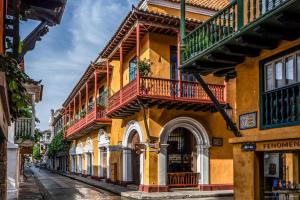 a yellow building with balconies on a street at Casa Trujillo in Cartagena de Indias