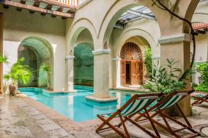 a swimming pool with a chair in a courtyard at Casa Trujillo in Cartagena de Indias