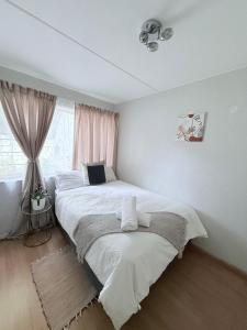 a bedroom with two beds and a window at Charming Hideaway in Sandton +10 photos