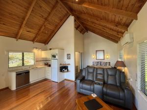 a living room with a couch and a kitchen at Abri Apartments in Paihia +32 photos