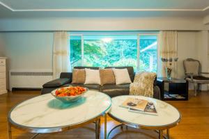 a living room with a couch and a bowl of fruit on a table at South Vancouver Garden Home in Vancouver