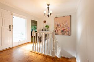 a white staircase in a home with a painting on the wall at South Vancouver Garden Home in Vancouver +13 photos