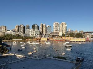 a harbor with boats in the water with a city at KozyGuru | MacMahons Point | Harbour Hideaway in Sydney +22 photos