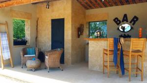 a porch with chairs and a bar on a patio at Fontaine de Cérier in Castillon-du-Gard