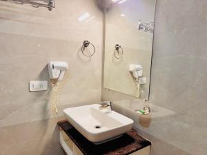 a white bathroom with a sink and a mirror at Staynest Continetal With parking Near Mg Marg in Gangtok +28 photos