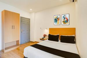 a bedroom with a large bed with a wooden headboard at Townhouse Sarjapur Road Formerly Hotel Ace in Bengaluru +23 photos