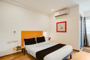 Un dormitorio con una cama grande en una habitación. en Townhouse Sarjapur Road Formerly Hotel Ace, en Bangalore