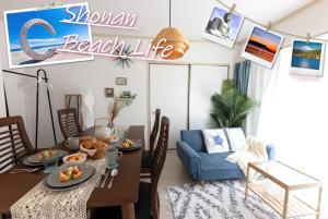 茅ヶ崎市にあるサザンビーチヴィラ ビーチまで徒歩5分 無料駐車場付 最大5名 湘南ライフのテーブルと青いソファのあるリビングルーム