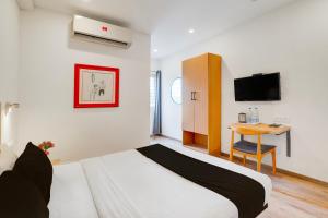 Un dormitorio con una cama y un escritorio con televisión. en Townhouse Sarjapur Road Formerly Hotel Ace, en Bangalore 22 fotos más