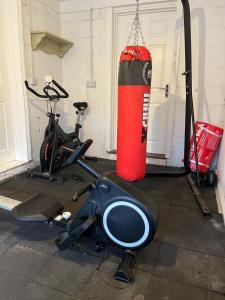 a gym with a punching bag and a exercise bike at South Wales Coastal Retreat in Llanelli