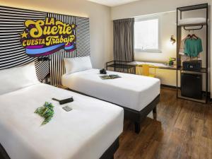 a hotel room with two beds and a sign that reads sd savage sushi truck at ibis styles Lima San Isidro in Lima