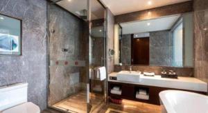 a bathroom with a tub and a sink and a shower at Ramada by Wyndham Wuhan Dongxihu in Wuhan +37 photos
