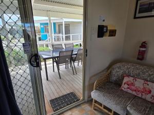 sala de estar con puerta de cristal que da a un patio en Jurien Bay View Bungalows Jetty View 5, en Jurien Bay