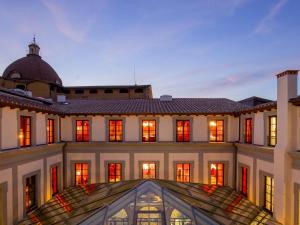 a large white building with red lights on it at 25hours Hotel Florence Piazza San Paolino in Florence