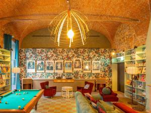 a living room with a pool table and a chandelier at 25hours Hotel Florence Piazza San Paolino in Florence