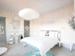 a white bedroom with a large bed and a sink at 25hours Hotel Florence Piazza San Paolino in Florence +107 photos