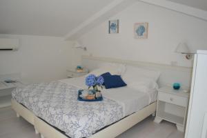 a bed with a white blanket and pillows on top of it at Al Centro Suites in Sorrento