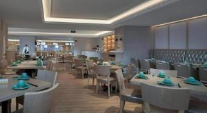 深セン市にあるBest Sleep International Hotel Shenzhen Tanglang Metro Stationのテーブルと椅子が備わるレストランで、シェフが座り込んでいます。