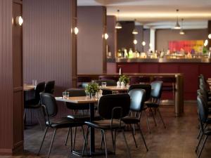 Un restaurante con mesas y sillas y un bar. en Mercure Perth On Hay, en Perth