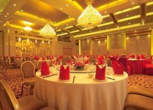 Un salón de banquetes con mesas y sillas blancas y candelabros. en Golden Diamond Hotel Zhongshan, en Zhongshan 250 fotos más