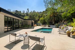 a patio with a table and chairs next to a pool at Valea Estate in Beverly Glen
