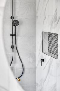 a shower with a shower head in a bathroom at The Palms Apartments in Merimbula +66 photos
