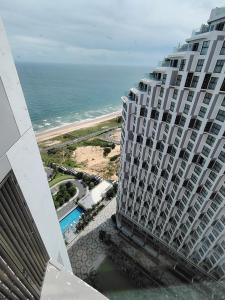 une vue sur l'océan depuis le balcon d'un immeuble dans l'établissement Apec Mandala wyndham Apartment - APEC Mui Ne, à Mui Ne