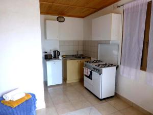 a small kitchen with a stove and a refrigerator at Verde in Santa Margherita di Pula