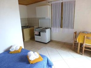 a small kitchen with two beds and a stove at Verde in Santa Margherita di Pula