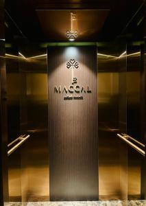 Maccal Boutique Hotel Dalat في دالات: غرفة ملابس مع علامة ماسالا على الحائط