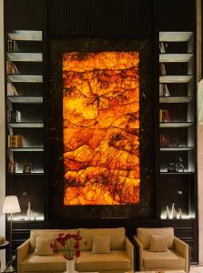 Maccal Boutique Hotel Dalat في دالات: غرفة معيشة مع لوحة كبيرة على الحائط