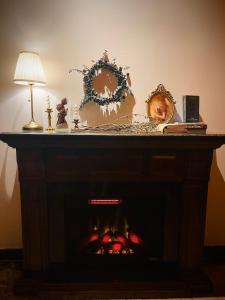 Maccal Boutique Hotel Dalat في دالات: طاولة مع مدفأة ومصباح ومرايا