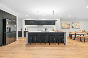 a kitchen with a large island with bar stools at Breach House Rhyll in Rhyll