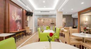 a dining room with tables and green chairs at Jinjiang Inn Select Shanghai Expo Park Dezhou Road in Shanghai