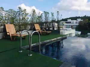 two chairs sitting next to a swimming pool at Neca Reiche in Hat Yai