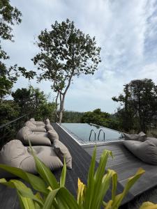 a pool with pillows on a deck with a tree at Villa Hillcrest in Weligama