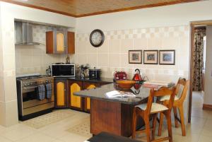 uma cozinha com um balcão e uma mesa com cadeiras em 125 on Van Buuren Road Guest House em Joanesburgo