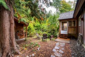 Cabaña con sillas, mesa y árbol en Rhododendron Cabin Near Mt Hood Adventures, en Brightwood