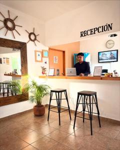 a man standing at a counter with a laptop at Hospedaje Casa Teotleco in Tepoztlán
