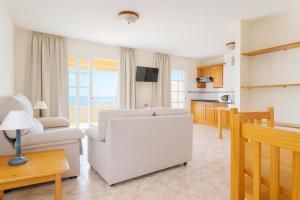 a living room with a couch and a chair at Be five Playa La Arena in Puerto de Santiago