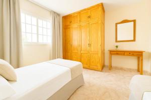 a bedroom with a bed and a wooden cabinet at Be five Playa La Arena in Puerto de Santiago +25 photos