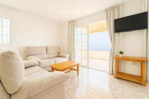 a living room with a couch and a table at Be five Playa La Arena in Puerto de Santiago