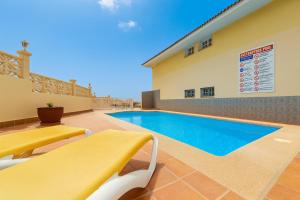 a swimming pool in front of a building at Be five Playa La Arena in Puerto de Santiago