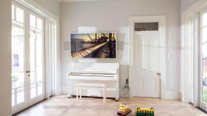 a white piano in a room with a painting on the wall at Kutti Beach House in Sydney